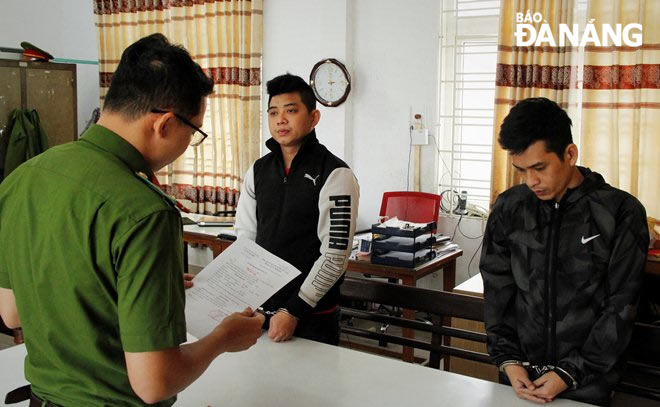 Cơ quan cảnh sát điều tra, Công an quận Thanh Khê đọc lệnh bắt tạm giam đối tượng Trần Văn Phước và Hồ Duy Phong. Ảnh: L.HÙNG