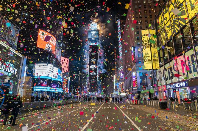 Hàng triệu mảnh hoa giấy ghi điều ước Năm mới tung bay rực rỡ khi quả cầu pha lê được thả xuống trên Quảng trường Thời đại ở New York, Mỹ vào thời khắc giao thừa ngày 1/1/2021. Ảnh: AFP/TTXVN