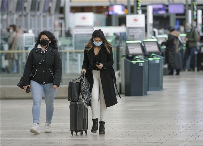 Hành khách đeo khẩu trang phòng dịch COVID-19 tại sân bay ở British Columbia, Canada ngày 22/12/2020. Ảnh: THX/TTXVN