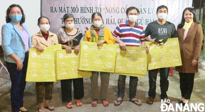 Người dân khu dân cư 2B Sơn Thủy được Hội Liên hiệp Phụ nữ thành phố Đà Nẵng tặng túi rác hỗ trợ việc phân loại rác. 			     Ảnh: H.L