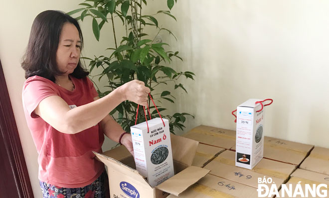 Mrs Pham Thi Hai Nguyet, the owner of the Hiep Hai fish sauce making establishment, packaging her products to prepare for sale.