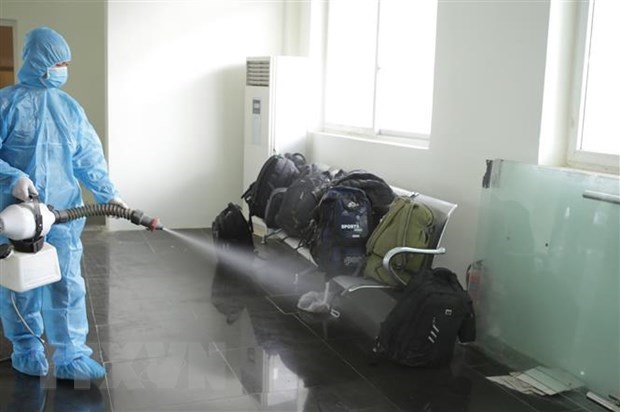 A medical worker disinfects luggage of people entering Viet Nam illegally (Source: VNA)
