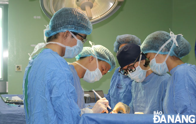 Ê-kip bác sĩ Bệnh viện Đà Nẵng phẫu thuật cho bệnh nhân bị chấn thương tủy sống.					     		             Ảnh: PHAN CHUNG - LÊ HÙNG