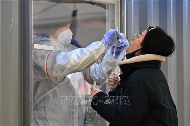 Nhân viên y tế lấy mẫu dịch xét nghiệm COVID-19 cho người dân tại Seoul, Hàn Quốc, ngày 16/12/2020. Ảnh: AFP/TTXVN