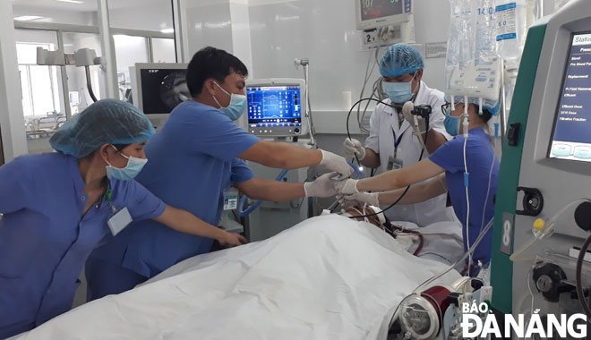 Các bác sĩ Khoa Hồi sức tích cực, Bệnh viện Đà Nẵng triển khai kỹ thuật ECMO để cứu sống bệnh nhân nguy kịch. Ảnh:PHAN CHUNG - LÊ HÙNG