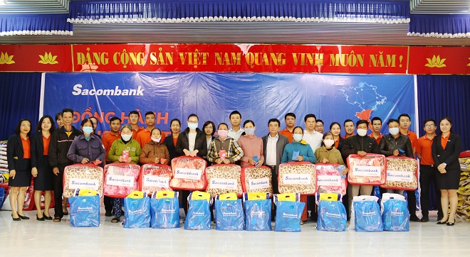Các hộ khó khăn phường Điện Nam Trung (thị xã Điện Bàn) nhận quà hỗ trợ của Sacombank trao tặng. Ảnh THANH TÌNH 