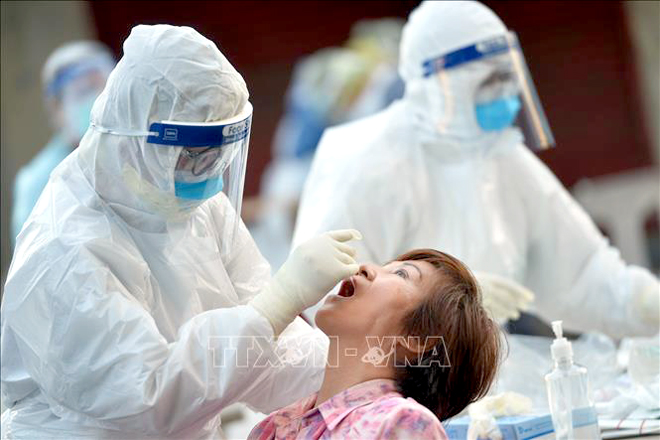  Nhân viên y tế lấy mẫu xét nghiệm Covid-19 tại tỉnh Samut Sakhon, Thái Lan. Ảnh: THX/TTXVN