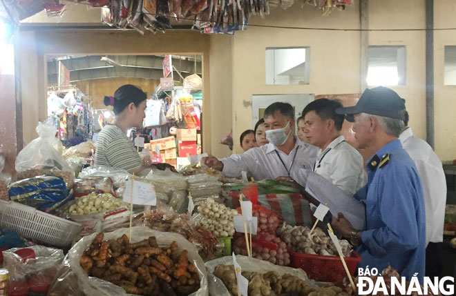 Lực lượng chức năng kiểm tra việc bảo đảm an toàn thực phẩm tại chợ Phước Mỹ.   						Ảnh: THÀNH LÂN