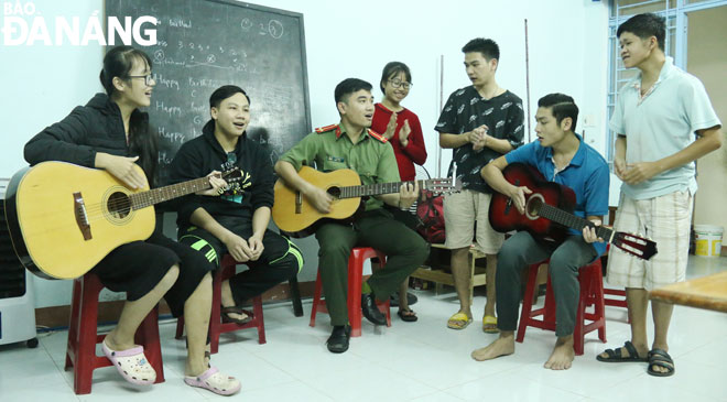 Trung úy Lê Hoàn (thứ ba, từ trái sang) dạy nhạc cho các bạn trẻ khuyết tật tại Trung tâm Hướng nghiệp và Từ thiện thuộc Hội Chữ thập đỏ thành phố. Ảnh: THANH TÌNH