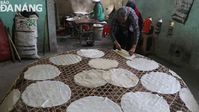 Freshly-made rice papers are being dried on charcoal fires