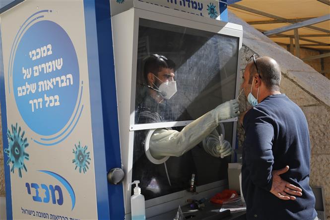 Nhân viên y tế lấy mẫu xét nghiệm Covid-19 tại Modiin, Israel. Ảnh: THX/TTXVN