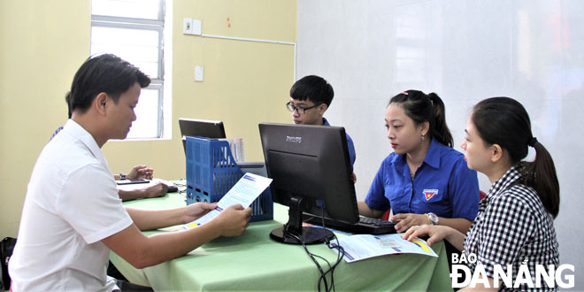 Đoàn viên thanh niên hỗ trợ người dân nộp hồ sơ trực tuyến tại “khu dân cư điện tử” Phước Hiệp, phường Nam Dương. 						Ảnh: ÁNH DƯƠNG