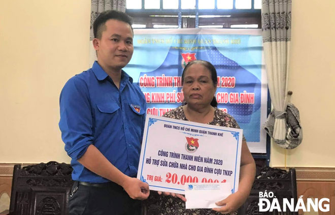 Đại diện Quận Đoàn Thanh Khê (trái) trao tặng kinh phí 20 triệu đồng hỗ trợ sửa chữa nhà cho gia đình bà Thái Thị Liễu, cựu Thanh niên xung phong.                Ảnh: NGUYỄN QUANG