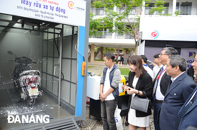 Các đại biểu tham quan gian trưng bày máy rửa xe tự động của sinh viên Khoa Cơ khí, Trường Đại học Bách khoa Đà Nẵng. Ảnh: NGỌC PHÚ