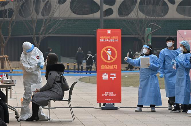 Nhân viên y tế lấy mẫu xét nghiệm Covid-19 cho người dân tại Seoul, Hàn Quốc ngày 23-12-2020. Ảnh: AFP/TTXVN