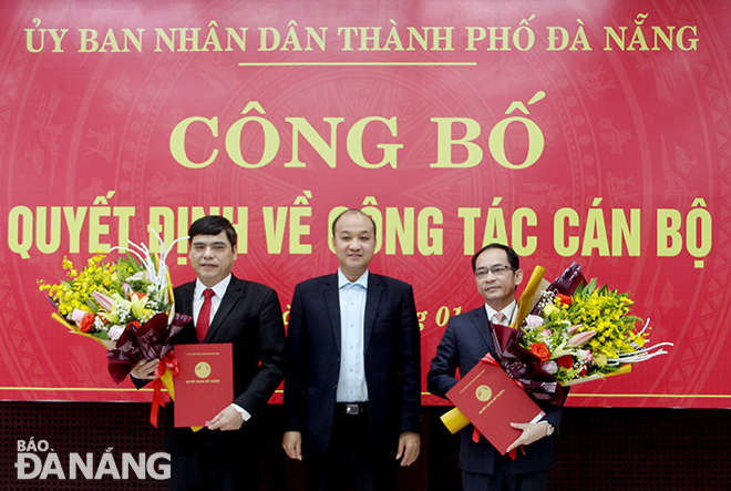 Phó Chủ tịch UBND thành phố Lê Quang Nam (giữa) trao quyết định và tặng hoa chúc mừng ông Lê Đức Viên (bìa phải) và ông Nguyễn Đăng Hoàng (bìa trái). Ảnh: ĐẶNG NỞ