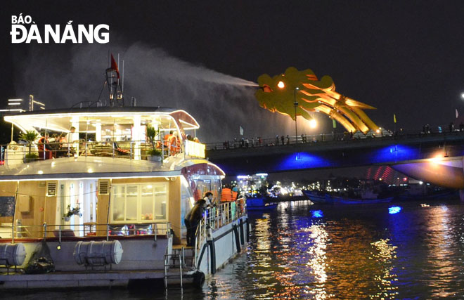 Visitors enjoying the weekend shows of fire breathing and water squirting at the eastern end of the Rong (Dragon) Bridge from the sightseeing tourist boats operating on the iconic Han River