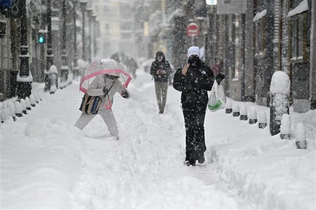 Người dân di chuyển khó khăn trên lớp tuyết dày tại một tuyến phố ở Madrid, Tây Ban Nha. (Ảnh: AFP/TTXVN)