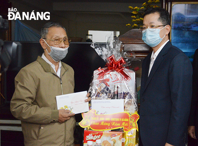 Bí thư Thành ủy Nguyễn Văn Quảng (bìa phải) tặng quà, chúc Tết gia đình thương binh Đặng Phước Mên. Ảnh: NGỌC PHÚ