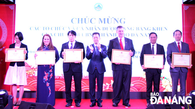 Da Nang Party Committee Secretary Nguyen Van Quang (centre) on Thursday honours the outstanding foreign organisations and individuals for their great devotion for the city's growth, as well as their active involvement in strengthening international friendship, and humanitarian aid work in the city over the past year