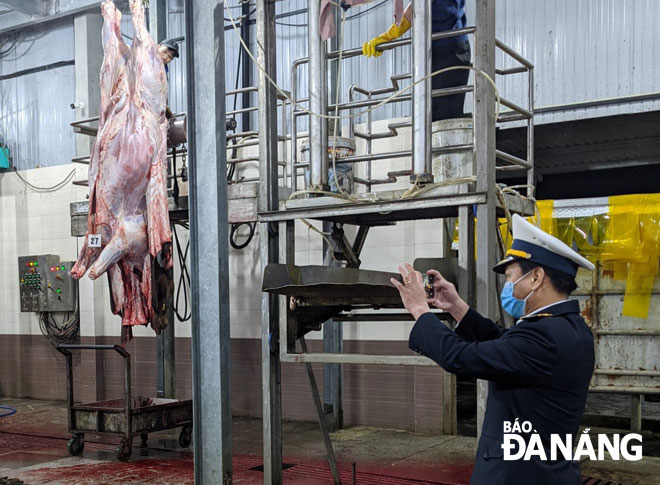 Staffers from the municipal Department of Livestock and Animal Health are inspecting the practice of food safety regulations at the Da Son poultry and livestock slaughtering establishment