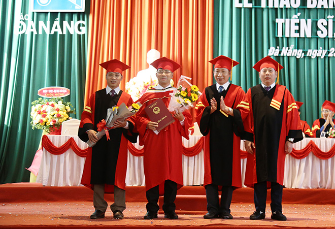 PGS.TS. Lê Thành Bắc (thứ 2 bên phải), Phó Giám đốc Đại học Đà Nẵng và PGS.TS. Nguyễn Mạnh Toàn (ngoài cùng bên phải) ,Trường Đại học Kinh trao bằng tiến sĩ cho  các cá nhân. Ảnh: NGỌC PHÚ