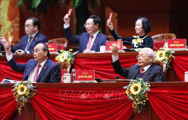 Party General Secretary and State President Nguyen Phu Trong and other members of the Presidium vote to adopt the agenda of the 13th National Party Congress. (Photo: VNA)