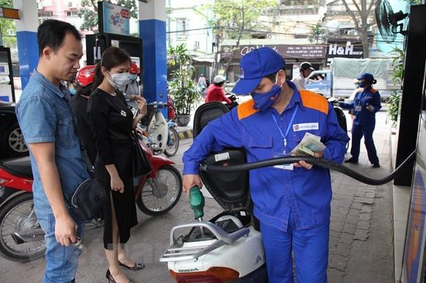 Nhân viên Petrolimex đang bán xăng cho khách hàng. (Ảnh: Đức Duy/Vietnam+)