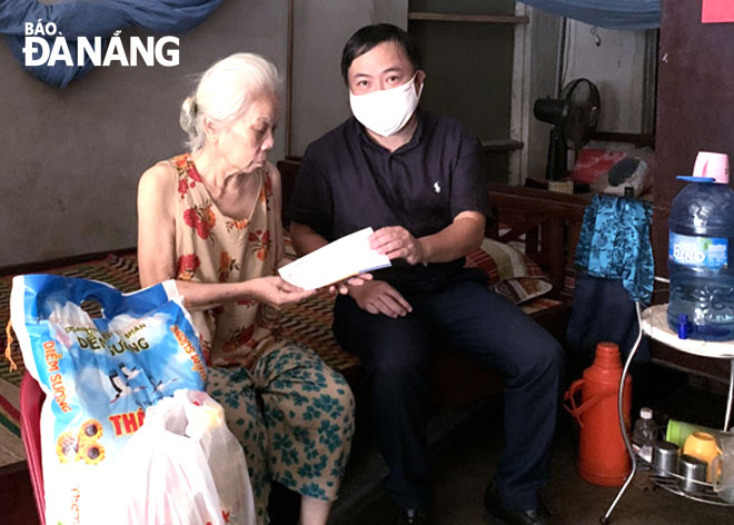 Thông qua sự giới thiệu của Ủy ban MTTQ Việt Nam phường Hòa Hiệp Bắc, đại diện Công ty Mobifone đến tặng quà và tiền cho bà Hoàng Thị Vui, tổ ở 26. Ảnh: THANH VÂN