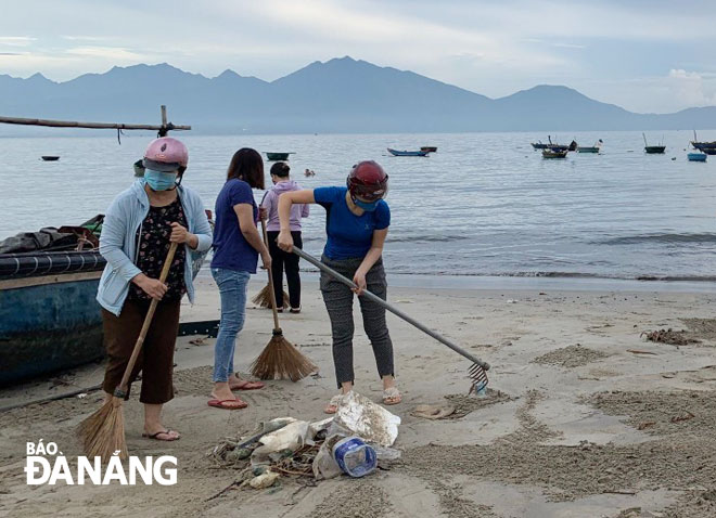 Người dân trên địa bàn quận Thanh Khê ra quân làm sạch bãi biển Nguyễn Tất Thành. Ảnh: Q.T