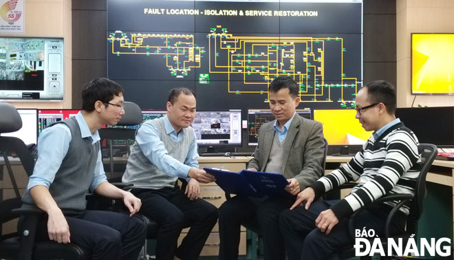Nhóm tác giả họp bàn về hệ thống tự động hóa lưới điện phân phối thông minh tại Trung tâm Điều khiển hệ thống điện Đà Nẵng. (Ảnh chụp đầu tháng 1-2021) 					            Ảnh: PHONG LAN