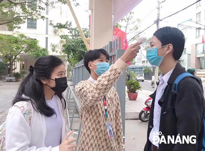 Học sinh Trường THPT Trần Phú (quận Hải Châu) được đo thân nhiệt trước khi vào lớp học. Ảnh: N.P