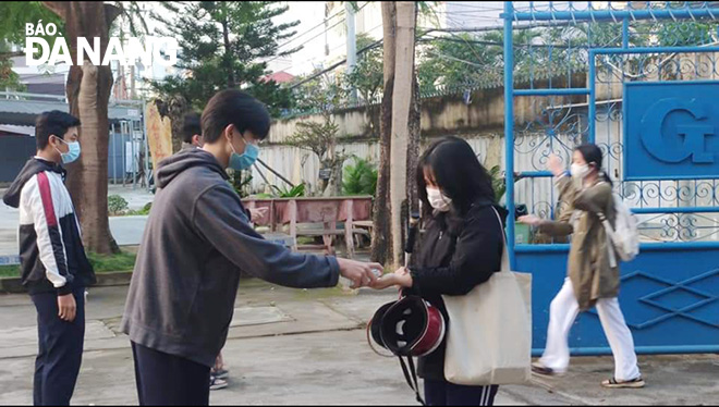 Học sinh Trường THPT Hoàng Hoa Thám (quận Sơn Trà) đươc đo thân nhiệt, sát khuẩn trước khi vào lớp học. Ảnh: N.P