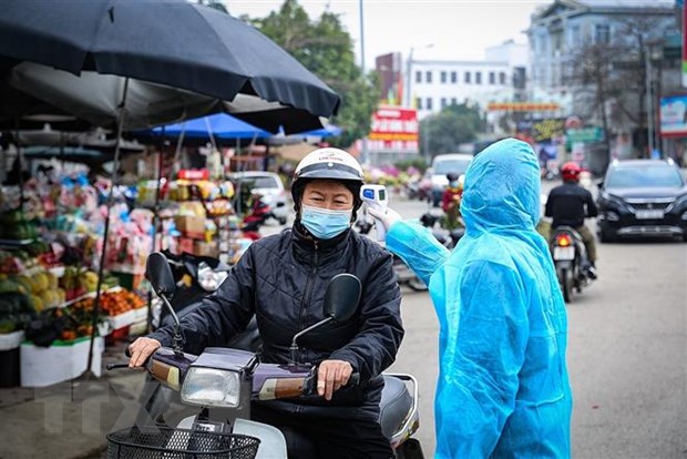 Điểm đo thân nhiệt cho người dân trước khi vào chợ. (Ảnh: Trọng Đạt/TTXVN)