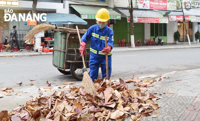 Công nhân Công ty CP Môi trường Đô thị Đà Nẵng làm nhiệm vụ trên tuyến đường Yên Bái, quận Hải Châu. Ảnh: NAM TRÂN