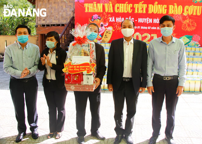 Da Nang People's Committee Vice Chairman Le Quang Nam (2nd right) presenting a Tet gift to the authorities of Hoa Bac Commune