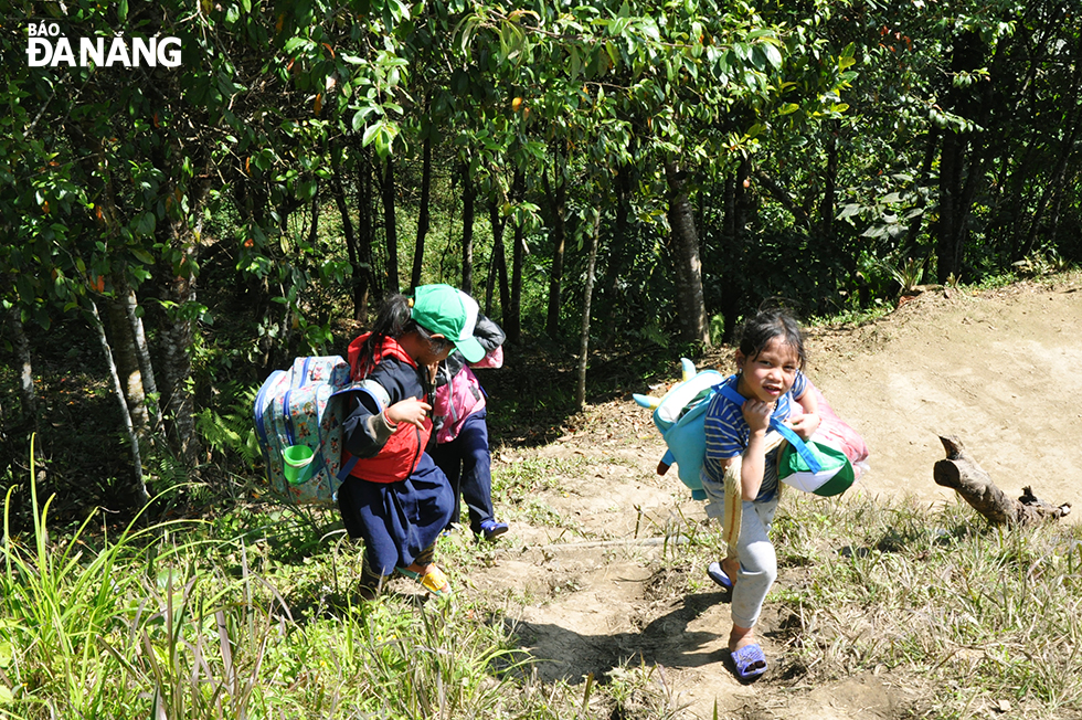 Co Tu ethnic children on way to school in harsh weather conditions.