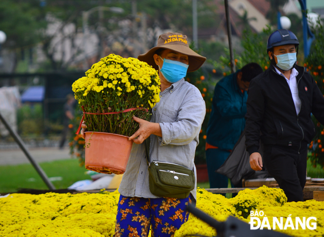 Traders touting for business at the Tet flower market located on 2 September Street wear face masks whilst conducting trading acts there.