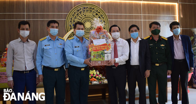 Phó Chủ tịch HĐND thành phố Lê Minh Trung (thứ 4, phải qua) tặng quà cho đại diện lãnh đạo Sư đoàn Không quân 372. Ảnh: T.S