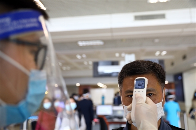 Passengers have temperatures taken before boarding their flights at Nội Bài International Airport.