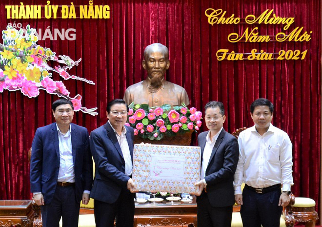 Trưởng Ban Nội chính Trung ương Phan Đình Trạc (thứ 2, trái sang) tặng quà chúc mừng năm mới đến lãnh đạo thành phố. Ảnh: LAM PHƯƠNG