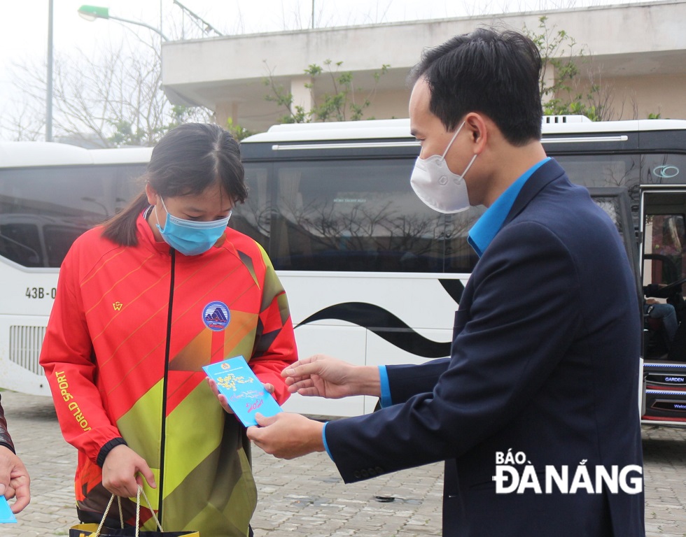 Chairman of the Da Nang Labour Union Nguyen Duy Minh giving lucky money to a coach passenger