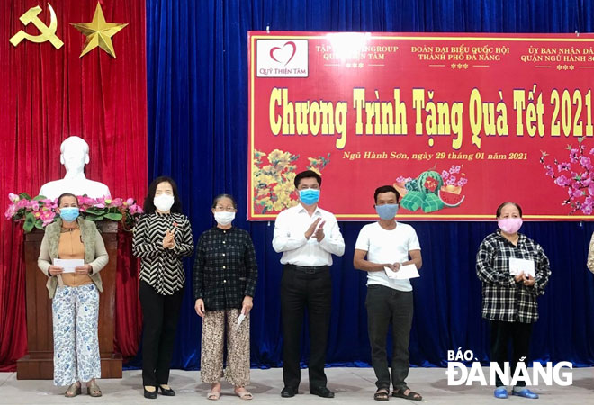 Ông Nguyễn Hòa, Chủ tịch UBND quận Ngũ Hành Sơn (thứ 3, phải sang) trao quà Tết cho hộ nghèo trên địa bàn quận nhân dịp Tết Tân Sửu 2021. Ảnh: N.QUANG