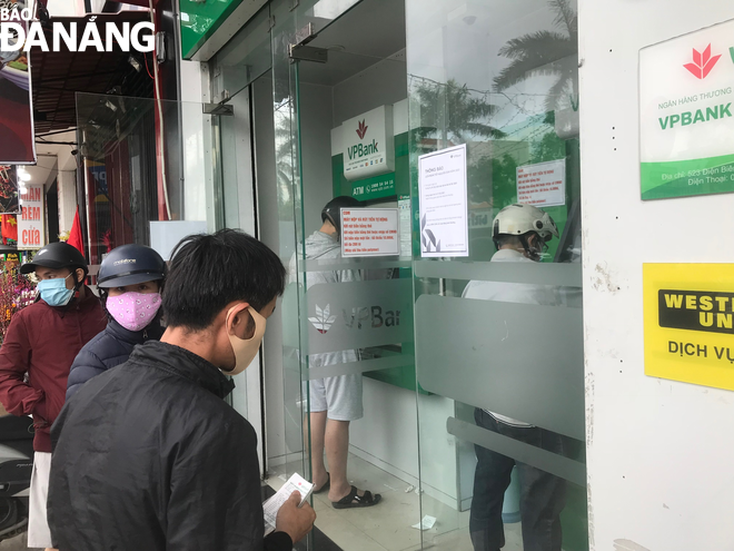 Cây ATM của Ngân hàng VP Bank (tuyến đường Điện Biên Phủ, quận Thanh Khê) có lắp đặt hệ thống CDM (thiết bị điện tử cho phép chủ tài khoản nộp tiền vào tài khoản của mình) nên có khá đông người dân chờ giao dịch. Ảnh: M.QUẾ