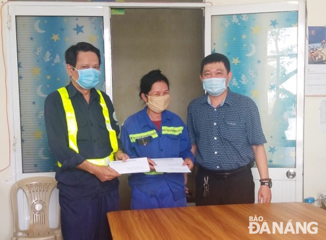 A representative from the Da Nang Urban Environment JSC (right) rewarding the two sanitation workers for having returned properties to their owners