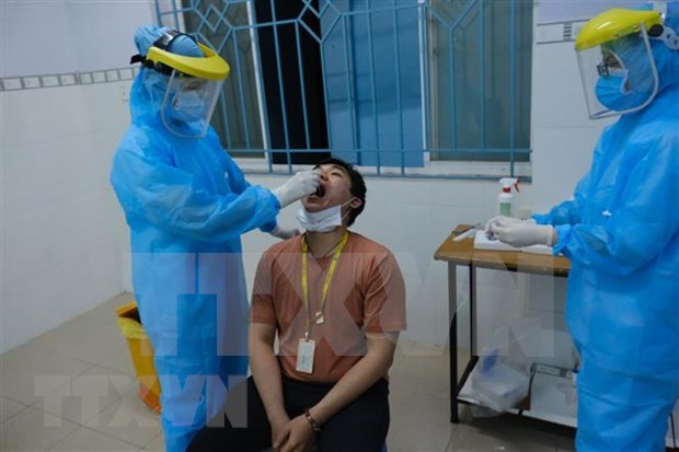 Specimen for COVID-19 testing is being collected from a staff at Ho Chi Minh City