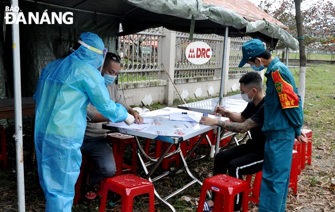 Lực lượng làm nhiệm vụ tải điểm chốt cửa ngõ trên tuyến đường Tạ Quang Bửu (quận Liên Chiểu) hướng dẫn hành khách khai báo y tế. Ảnh: L.HÙNG