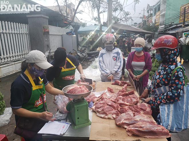 Người dân mua thịt heo bình ổn giá vào sáng 9-2 tại chợ Hòa Khánh (quận Liên Chiểu). Ảnh: KHÁNH HÒA