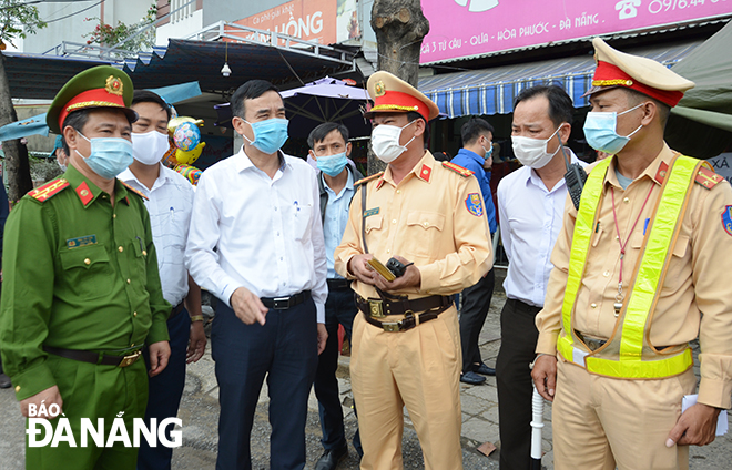 Chủ tịch UBND thành phố Lê Trung Chinh nghe lực lượng làm nhiệm vụ báo cáo tình hình công tác phòng, chống dịch. Ảnh: NGỌC PHÚ