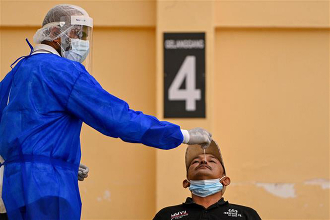 Nhân viên y tế lấy mẫu xét nghiệm Covid-19 cho người dân tại Petaling Jaya, Malaysia, ngày 18-1-2021. Ảnh: THX/ TTXVN